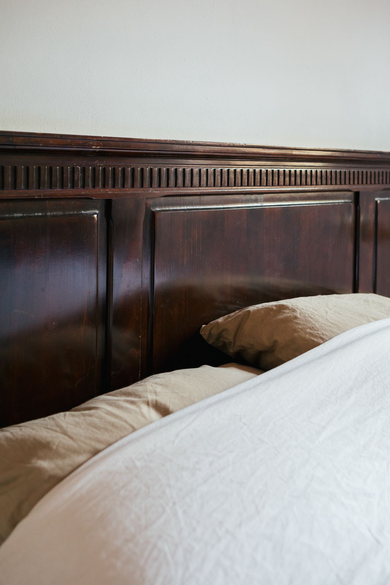 Crisp white bed linen and a wooden headboard
