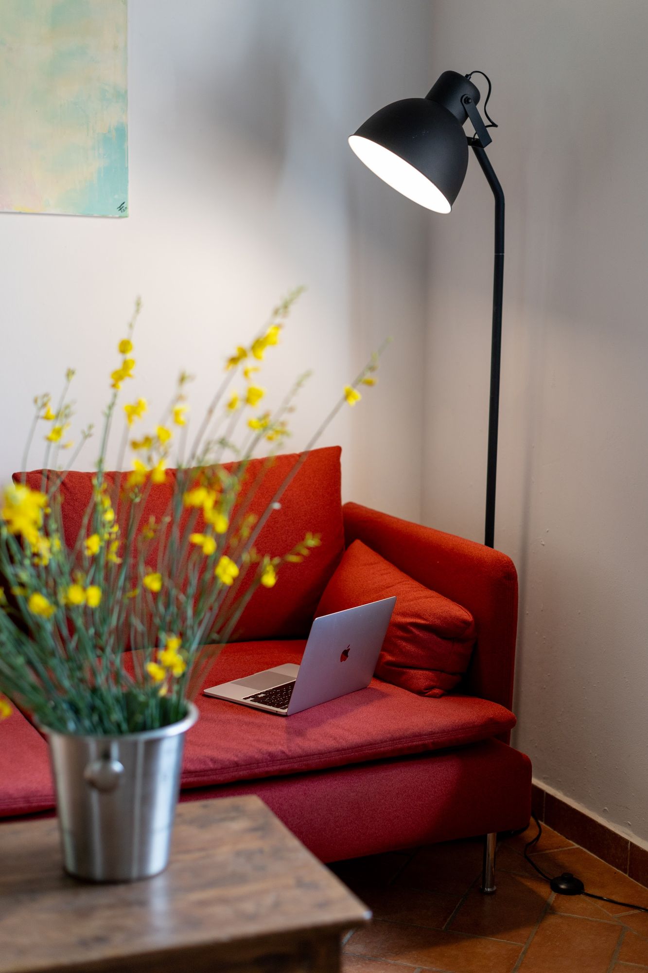 Spring flowers on a table beside the red sofa