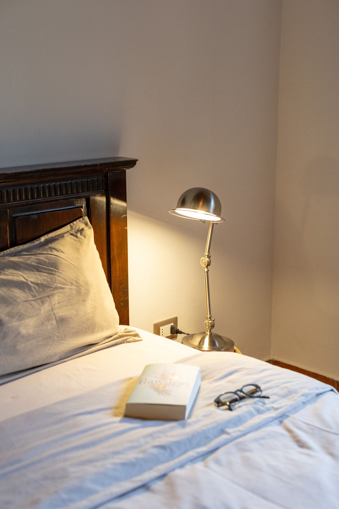 Bedside lamp and an open book in one of the bedrooms